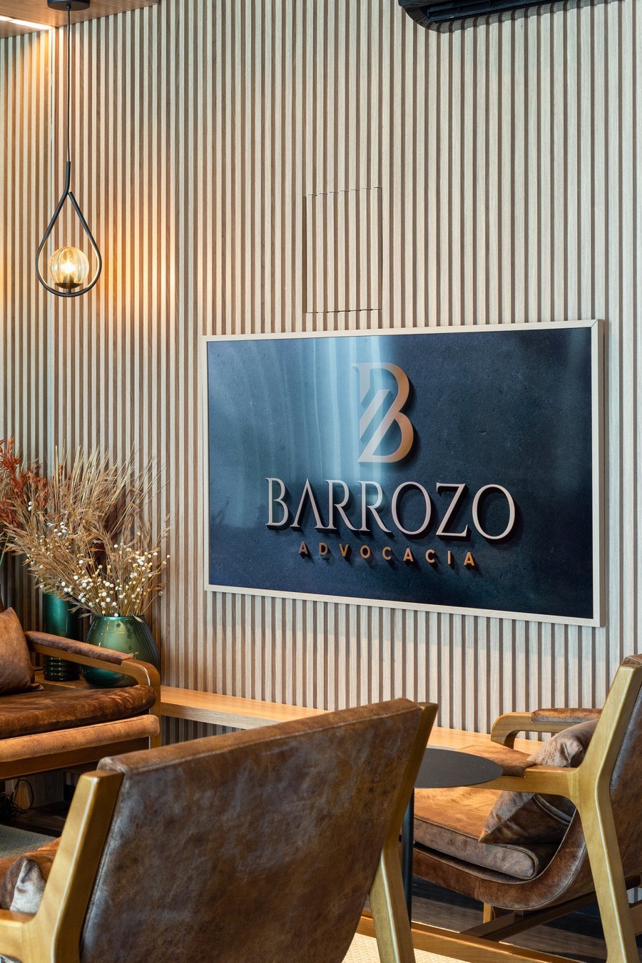 Painel da marca Barrozo Advocacia em parede ripada de madeira